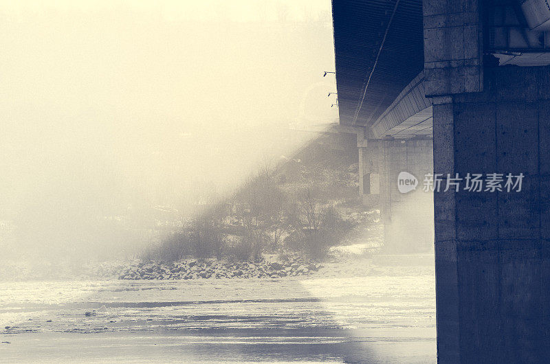 污染。污染的二氧化碳在桥下的河流上。冬天的形象。