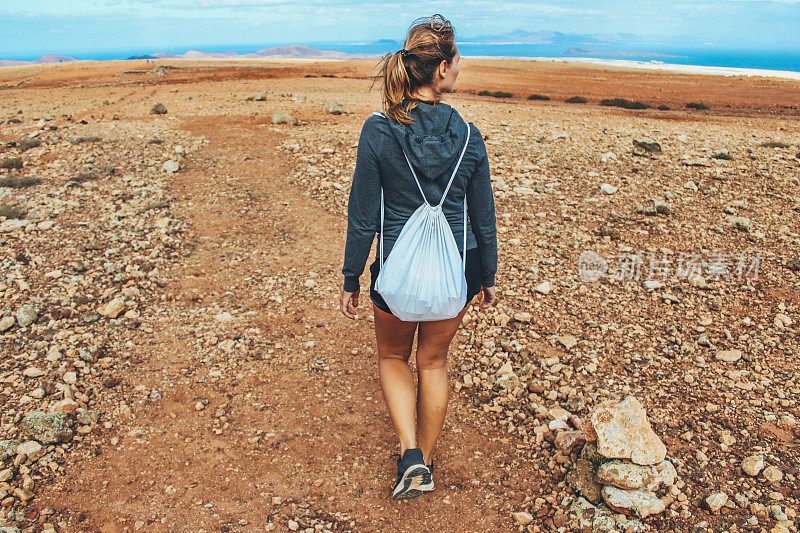 年轻女子徒步旅行与全景火山