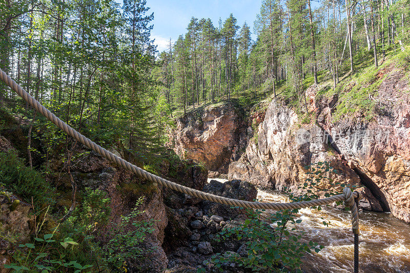高耸的云杉上的岩石上的暴风雨河，芬兰
