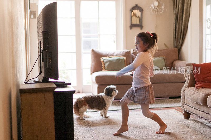 小女孩在家里电视机前跳舞