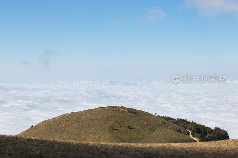 Subasio山(翁布里亚)的观点，山谷充满了雾，下面几乎是空的蓝色天空
