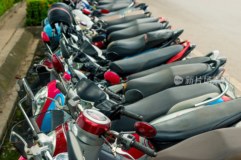停在泰国人行道上的一排摩托车上