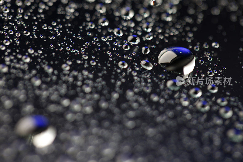 雨滴纹理上的玻璃凝结水滴黑色的背景接近