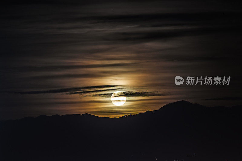 夜景-满月明亮地照耀在天空，云彩在山的背景。