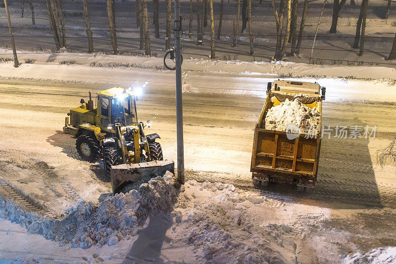 装载机在夜间清除积雪