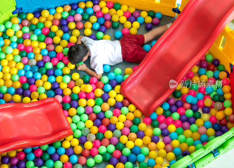 儿童游乐区的彩色塑料球和红色滑块