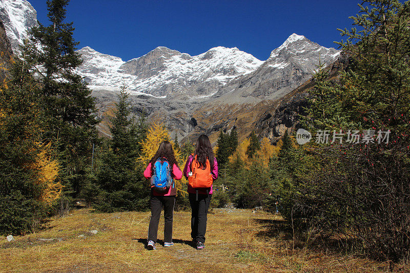 两名妇女在四川省西北部小金县的四姑娘山徒步旅行