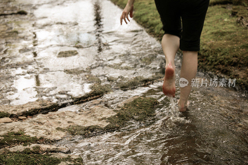 赤脚卷起裤子的女人放松在田纳西小溪