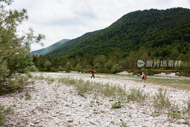 一对老年夫妇在欧洲阿尔卑斯山附近的河流徒步旅行