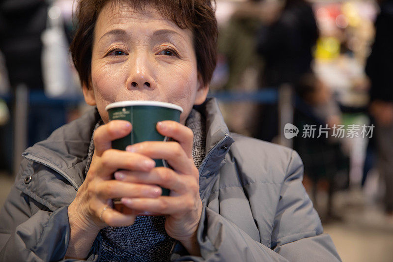 年长的女人在享受她的饮料