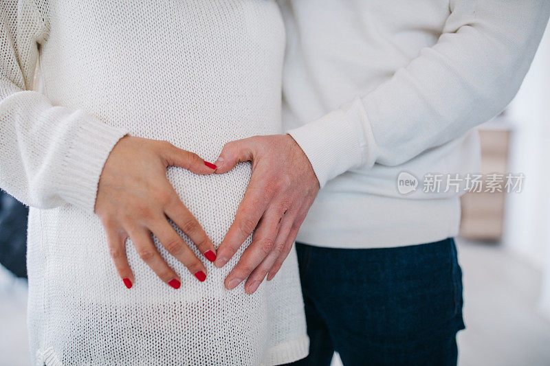 父母的手触摸孕妇的肚子