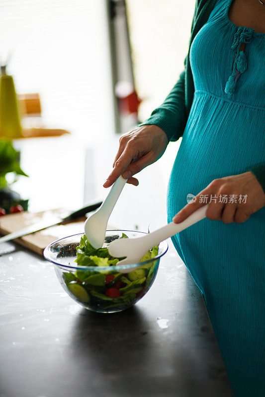 孕妇在拌蔬菜沙拉