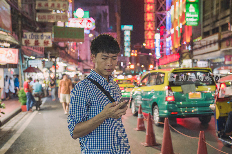 年轻的亚洲男人喜欢在泰国曼谷的中国城Yaowarat街旅游