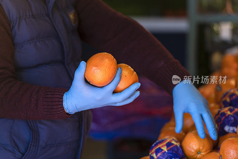 戴着橡胶手套的蔬菜水果商。