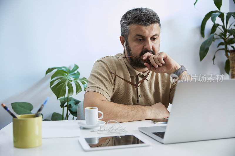 一个年轻人在他的家庭办公室里对着电脑说话