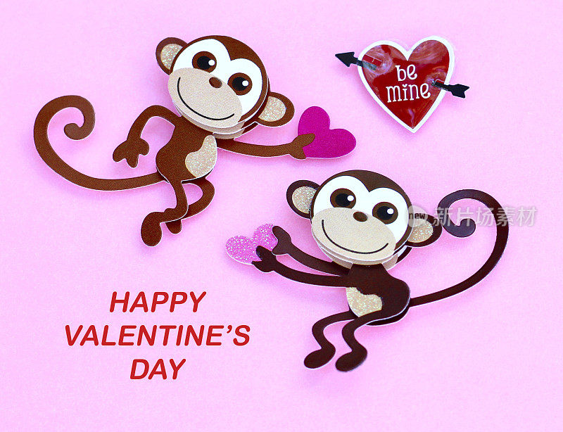 两只猴子捧着一颗心在粉红色的背景上微笑，上面写着快乐的情人节信息