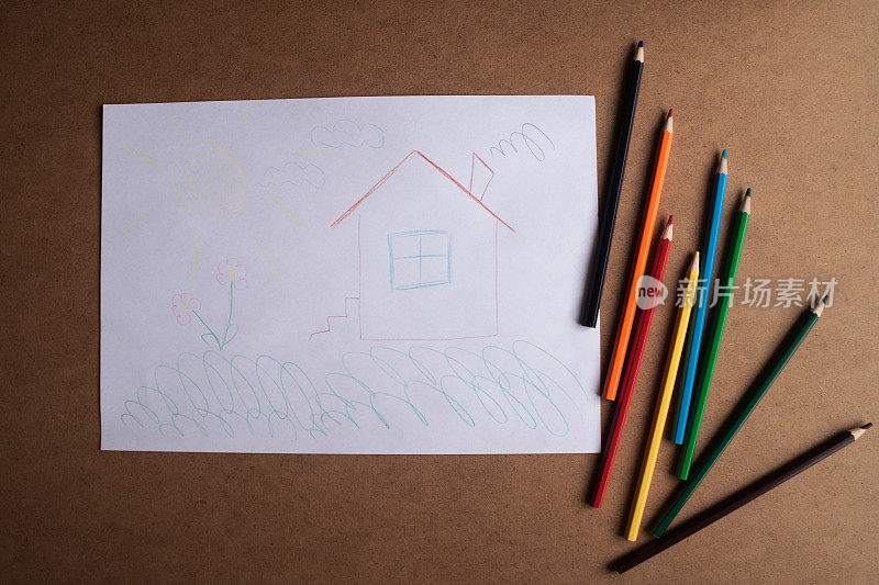 桌子上放着孩子们的图画和彩色铅笔。孩子们的创造力。孩子的问题。孩子梦想有一个舒适的房子。