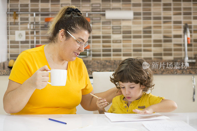 快乐的妈妈教她的小儿子如何写快乐的妈妈教儿子写和画