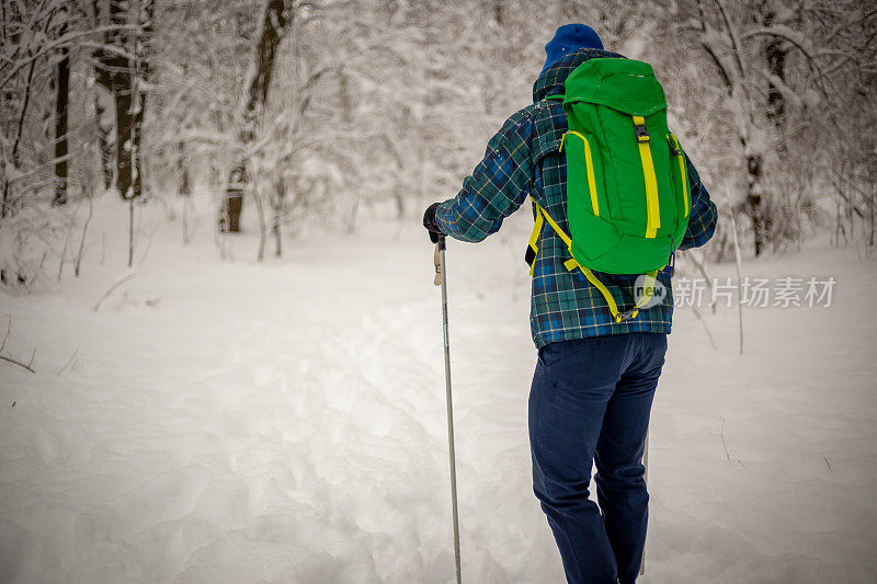 年轻英俊的男子在滑雪运动服山和看别处