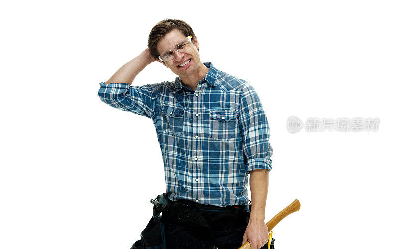 白人男性建筑工人站在白色背景下，穿着牛仔裤，手持锤子