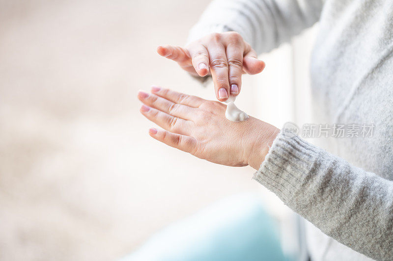 女人用护手霜擦干皮肤