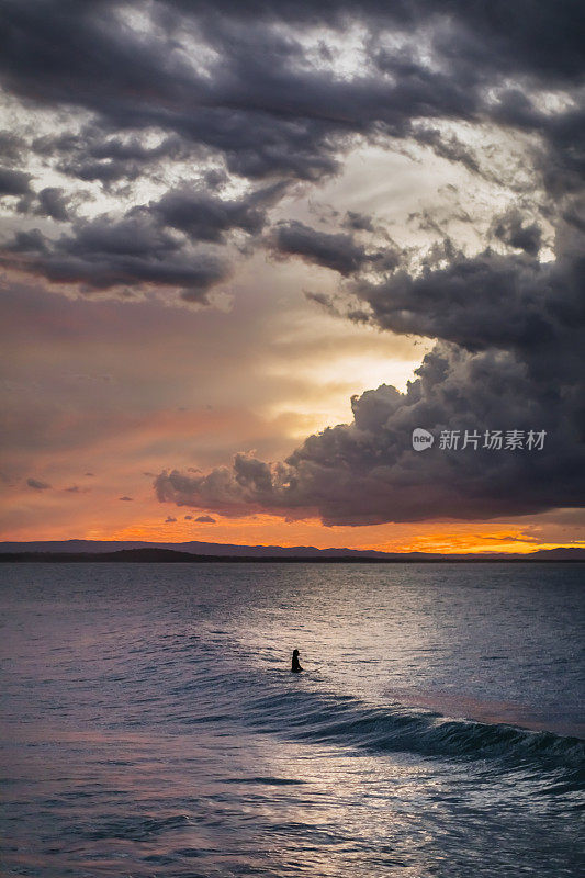 2020年5月9日，澳大利亚昆士兰，阳光海岸，努萨头，一名冲浪者在风暴后的日落时在努萨国家公园的茶树湾冲浪