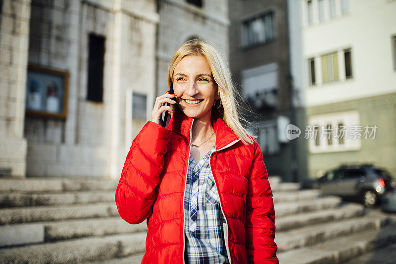 年轻的白种金发女人在用智能手机打电话