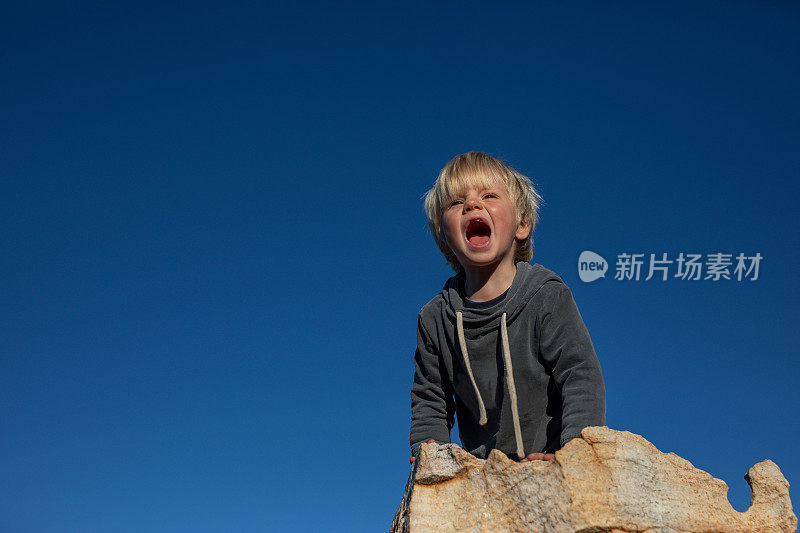 一个小男孩在南非塞德堡山的岩石上玩耍