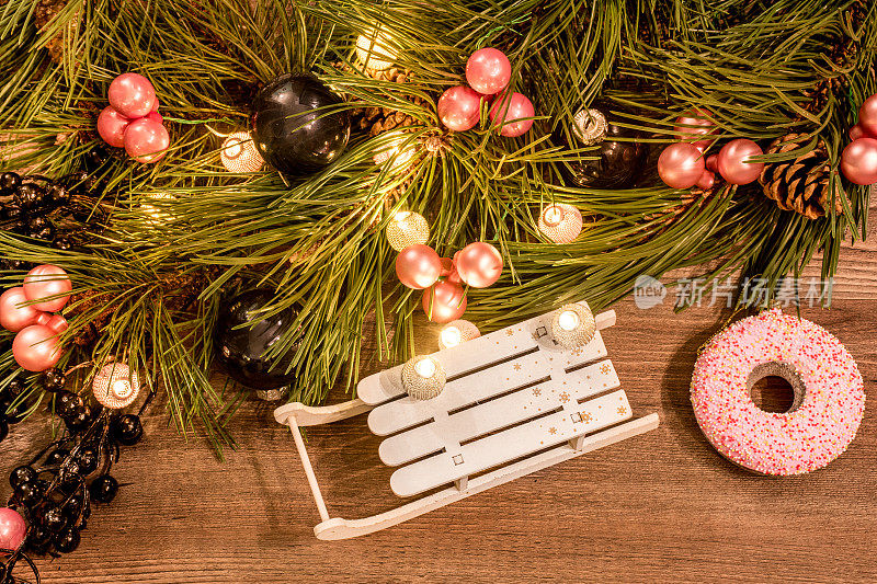 平铺圣诞构图与松树枝木制背景，圣诞装饰品和仙女灯