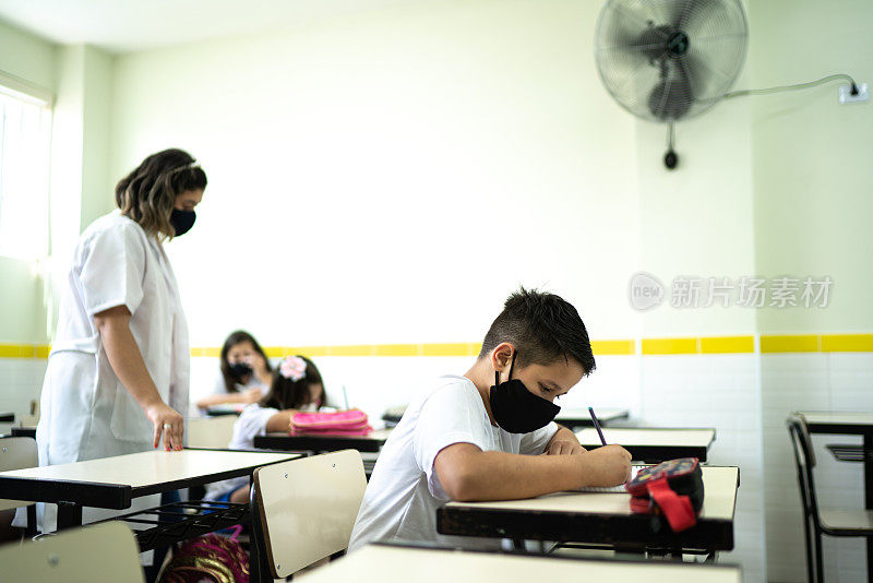 学生戴着口罩在教室里学习