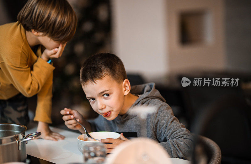 晚餐时间，两个小男孩在吃意大利面