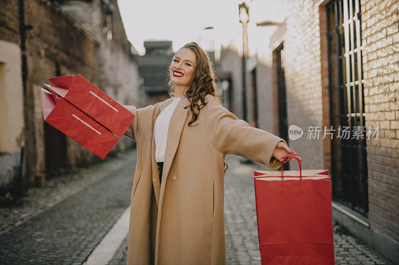 快乐的女人提着红色购物袋的肖像