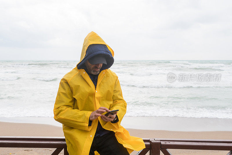 雨天，男人在海边的屋顶阳台上打电话。