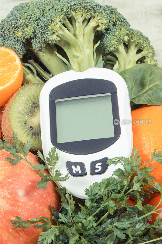 血糖测量仪用于测量血糖水平和水果蔬菜。糖尿病、健康生活方式和营养的概念