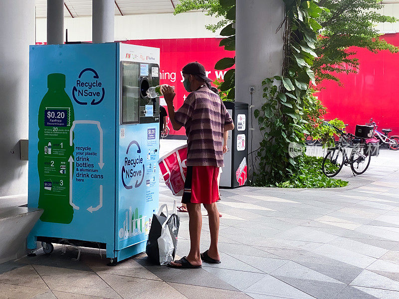 新加坡，Sep2020，一名男子在一台反向自动贩卖机中回收塑料瓶。回收空罐、塑料瓶时赚;回收NSave由国家环境局NEA和F&N。
