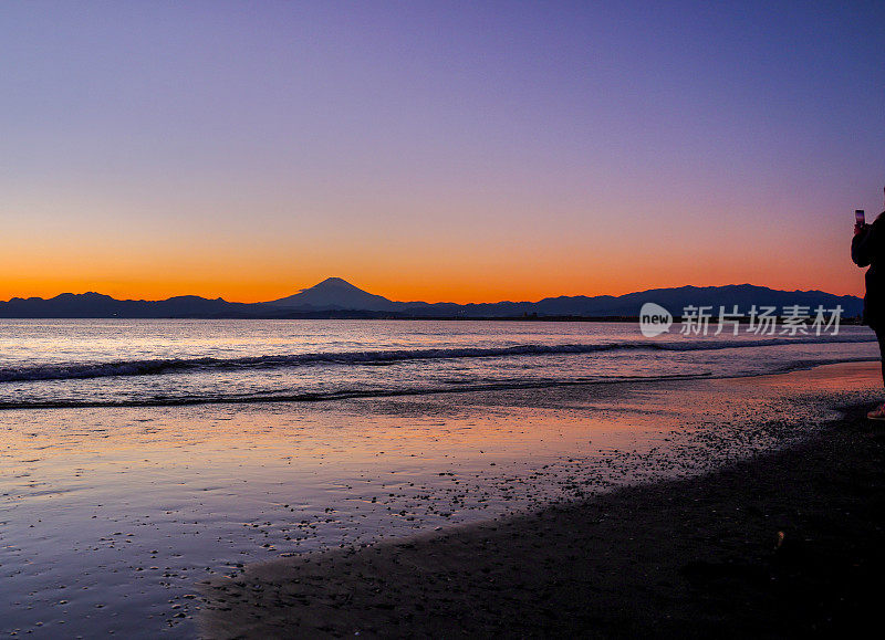 夕阳下，沙滩上的富士山轮廓