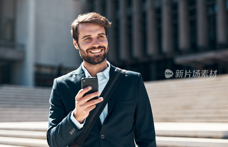 一名年轻商人在城市背景下使用智能手机的照片