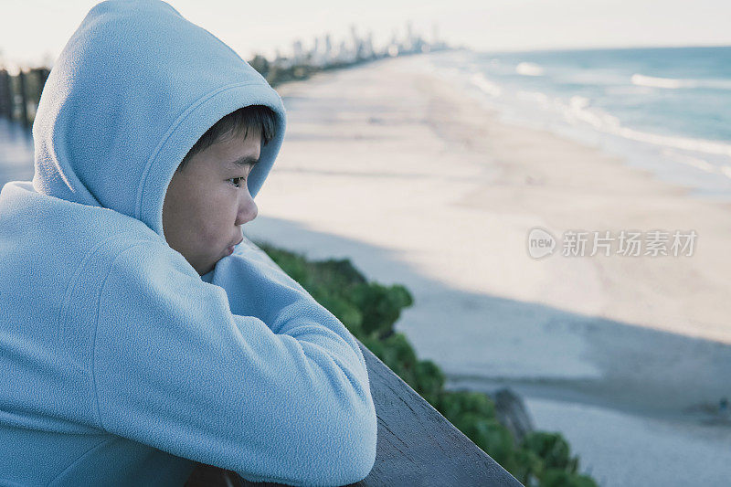 年轻的亚洲混血男孩看海洋，心理健康的生活方式的概念