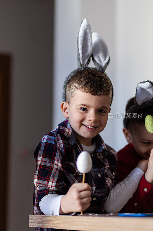 快乐的小男孩戴着复活节兔子耳朵