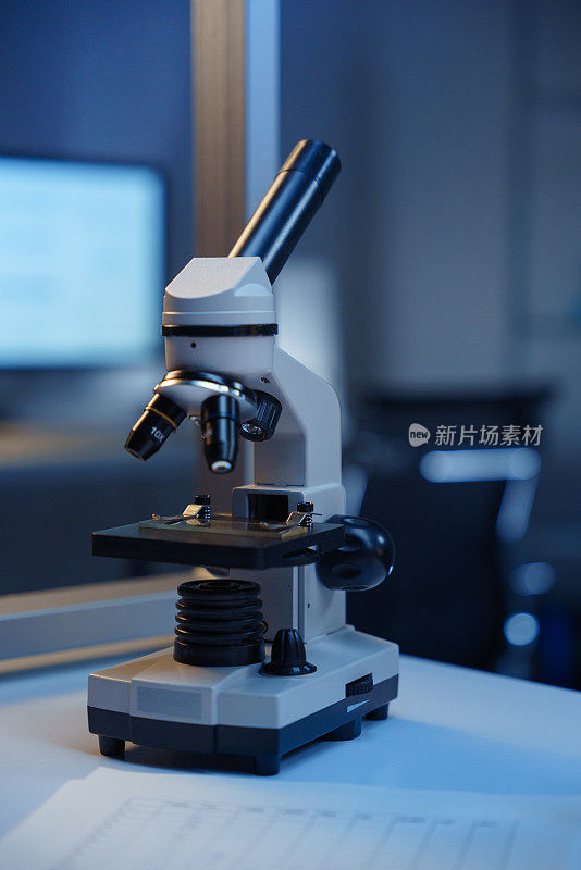 现代科学实验室桌子上模糊背景上的显微镜