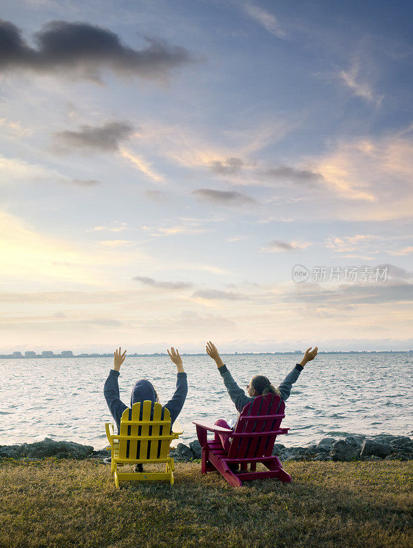 两个幸福的女人坐在海边看风景