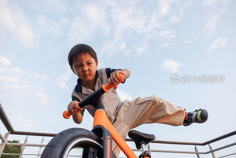 这个小男孩正在学骑自行车