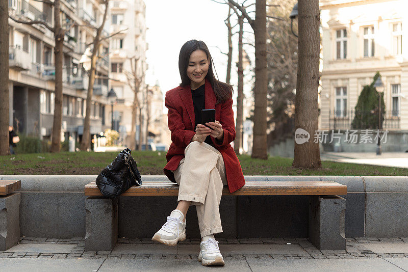 亚洲妇女在街上使用智能手机