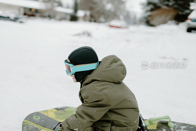 快乐的男孩坐在雪橇上