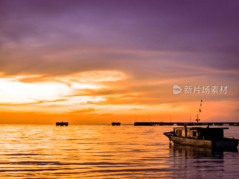 日落时分的户外风景，海上的渔夫船。