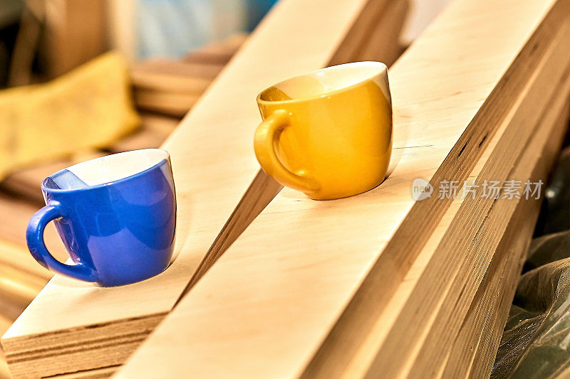 工作休息，喝茶喝咖啡的时间。蓝色和黄色的木杯子放在木板上
