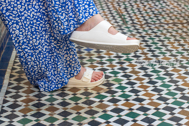 在摩洛哥马拉喀什麦地那地区的地板上，人脚上的凉鞋