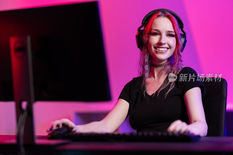专业微笑的电子竞技玩家女孩在PC上玩在线视频游戏