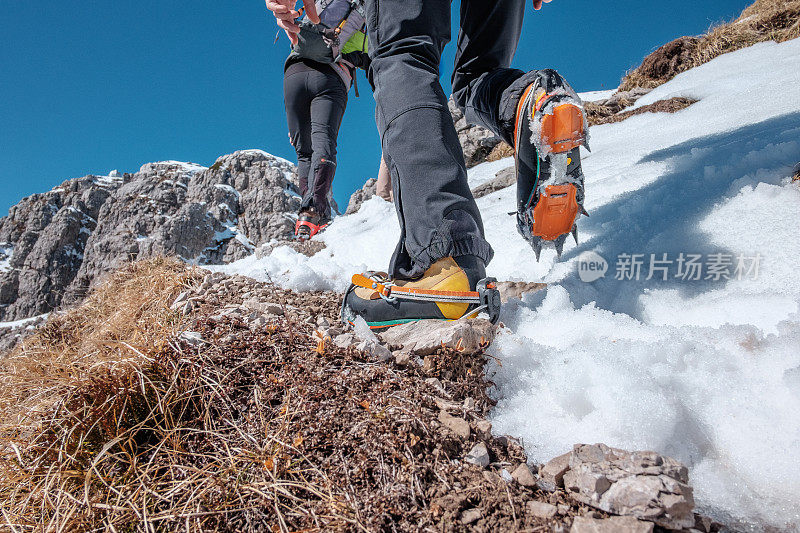 登山运动员在高山上装备了冰爪的小路上