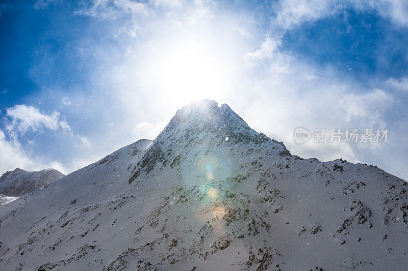 雪山在雪片中闪耀着阳光